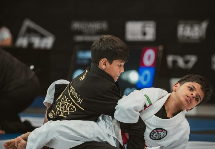 Our young athlete Ishaq competing in the Abu Dhabi Grand Slam 2025, wearing black gi uniforms, in an intense Jiu Jitsu match.
